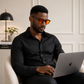 Homme portant des lunettes anti-lumière bleue à verres orange devant son ordinateur portable