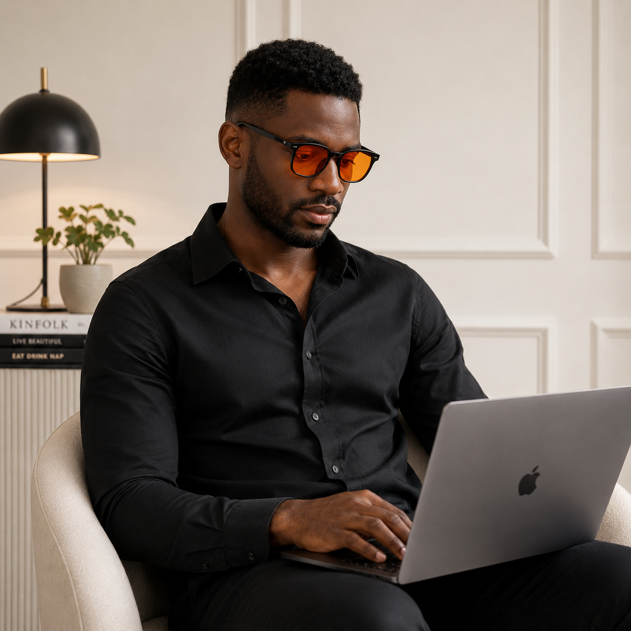 Homme portant des lunettes anti-lumière bleue à verres orange devant son ordinateur portable